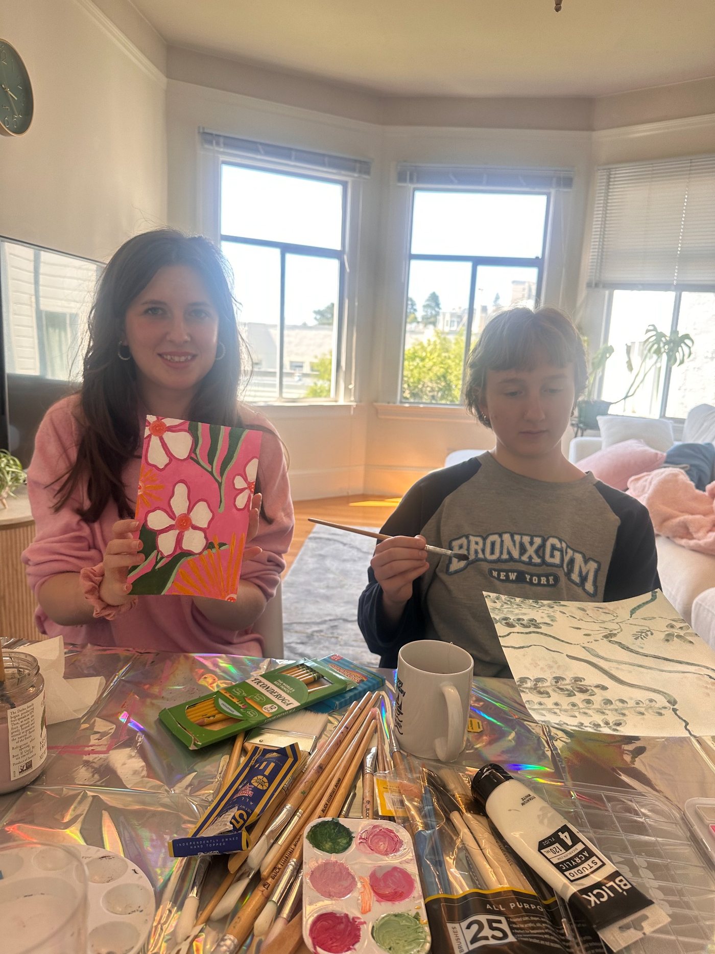 Olivia and participant painting indoors with art supplies on the table