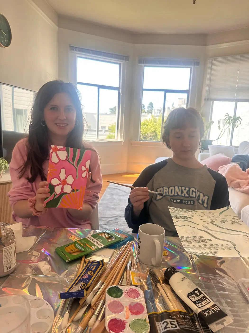 Olivia and a participant painting together during an individualized indoor community activity